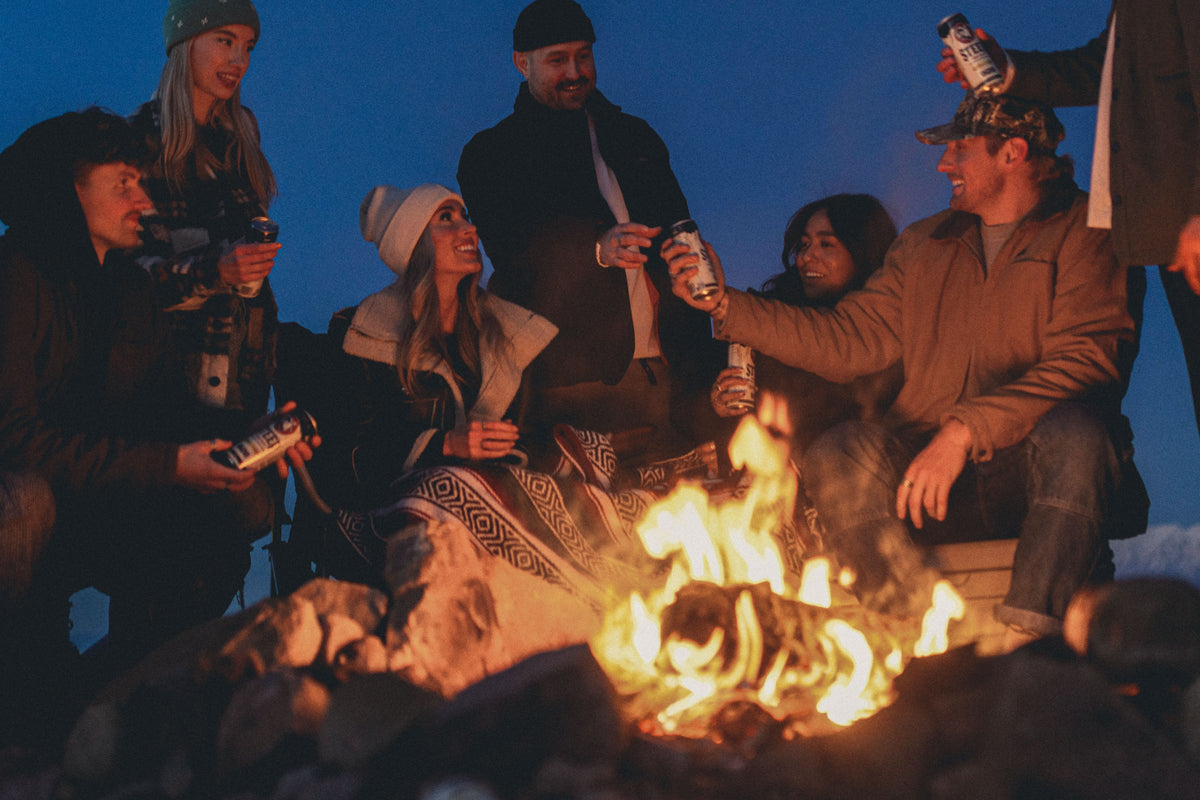 Group of people gathered around a campfire at night